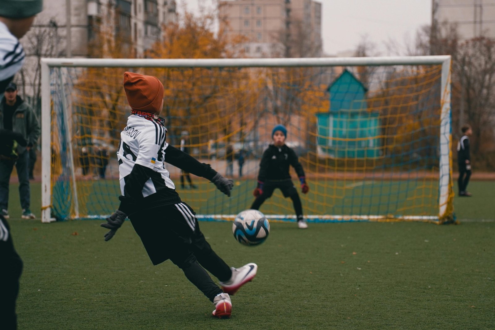 Children playing soccer on a cool autumn day in a park in Kyiv, Ukraine, enjoying outdoor sports.